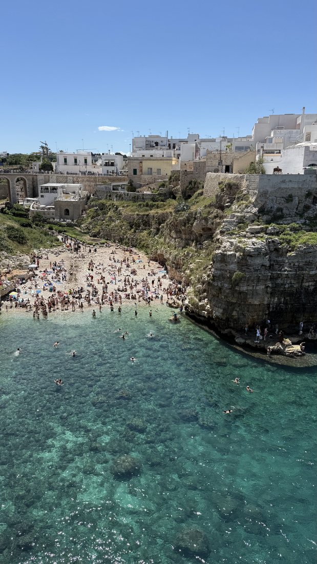 Turquoise cove beneath the cliffside town